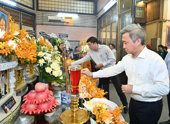 Đồng chí Đặng Minh Thông thắp nén hương, viếng tang các nạn nhân trong vụ cháy. (Ảnh: SGGP)