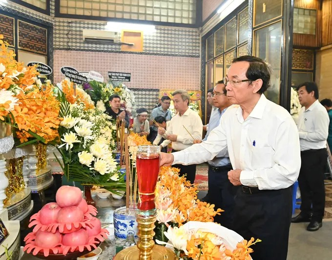 Đồng chí Nguyễn Văn Nên thắp nén hương, viếng tang các nạn nhân trong vụ cháy. (Ảnh: SGGP)
