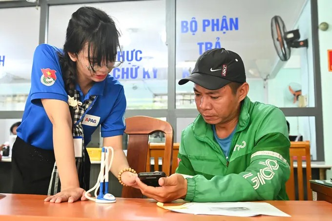 Thanh niên tình nguyện hỗ trợ người dân tại Trung tâm Phục vụ hành chính công phường. (Ảnh: SGGP)