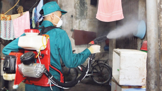 Cán bộ y tế phun hóa chất phòng chống bệnh sốt xuất huyết tại các hộ gia đình ở Hà Nội.