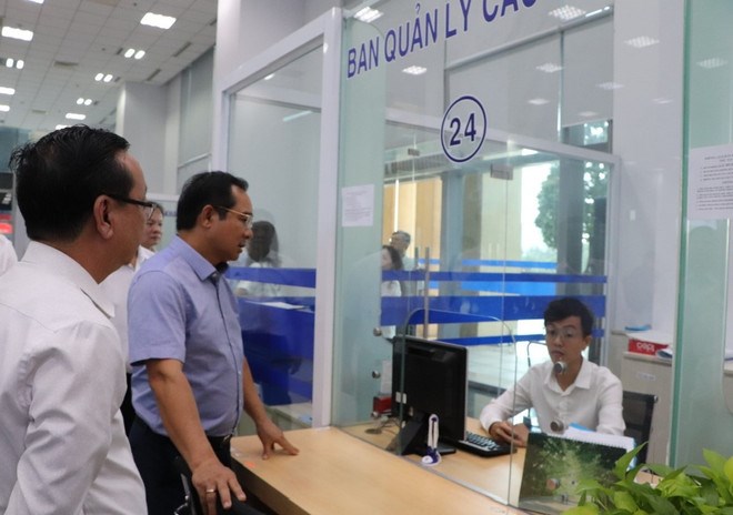 Chủ tịch thành phố trao đổi nghiệp vụ với chuyên viên. (Ảnh: TTXVN)