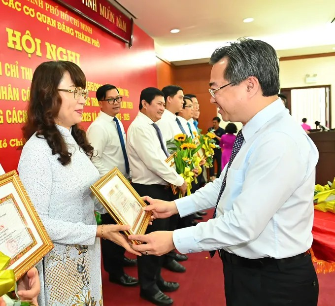 Phó Bí thư Thường trực Thành ủy TPHCM Nguyễn Thanh Nghị chúc mừng các cá nhân điển hình học và làm theo Bác giai đoạn 2016-2025. (Ảnh: SGGP)