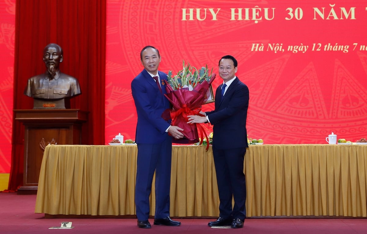 Bộ trưởng Đỗ Đức Duy tặng hoa chúc mừng Thứ trưởng Phùng Đức Tiến. Ảnh: Khương Trung.