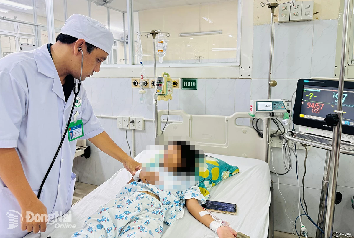 Bác sĩ Bệnh viện Nhi đồng Đồng Nai kiểm tra sức khỏe cho một bệnh nhi bị sốc sốt xuất huyết. Ảnh: Hạnh Dung  